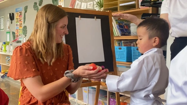 young male student at chengdu international school learning from teacher