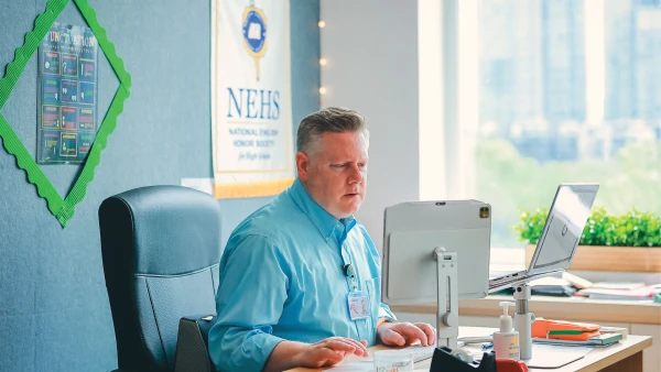 male teacher at chengdu international school learning on the computer