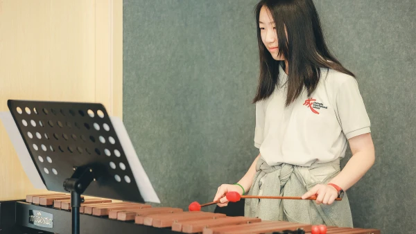 female student playing marimba at chengdu international school high school band class