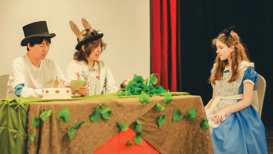 three students perform a theater show at chengdu international school news