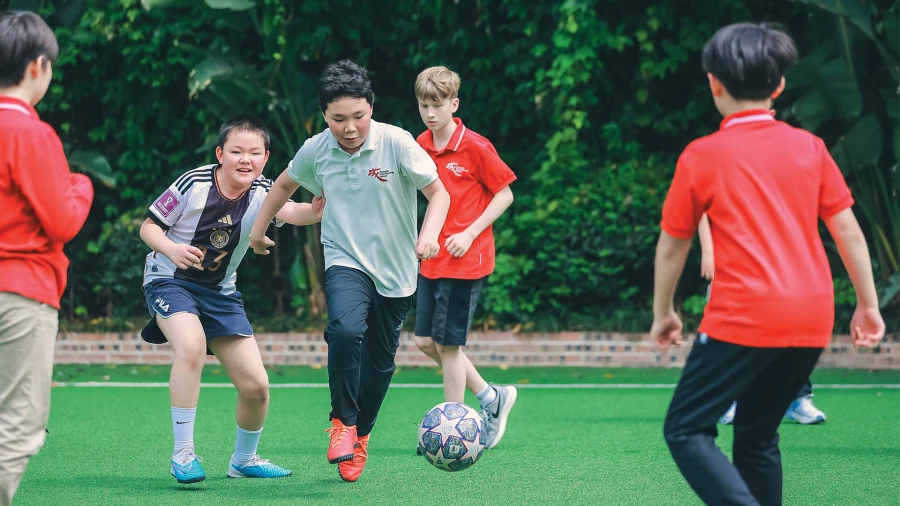 male students outside chengdu international school learning to play soccer